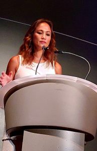 20240824_171857sm a woman standing at a podium with a microphone
