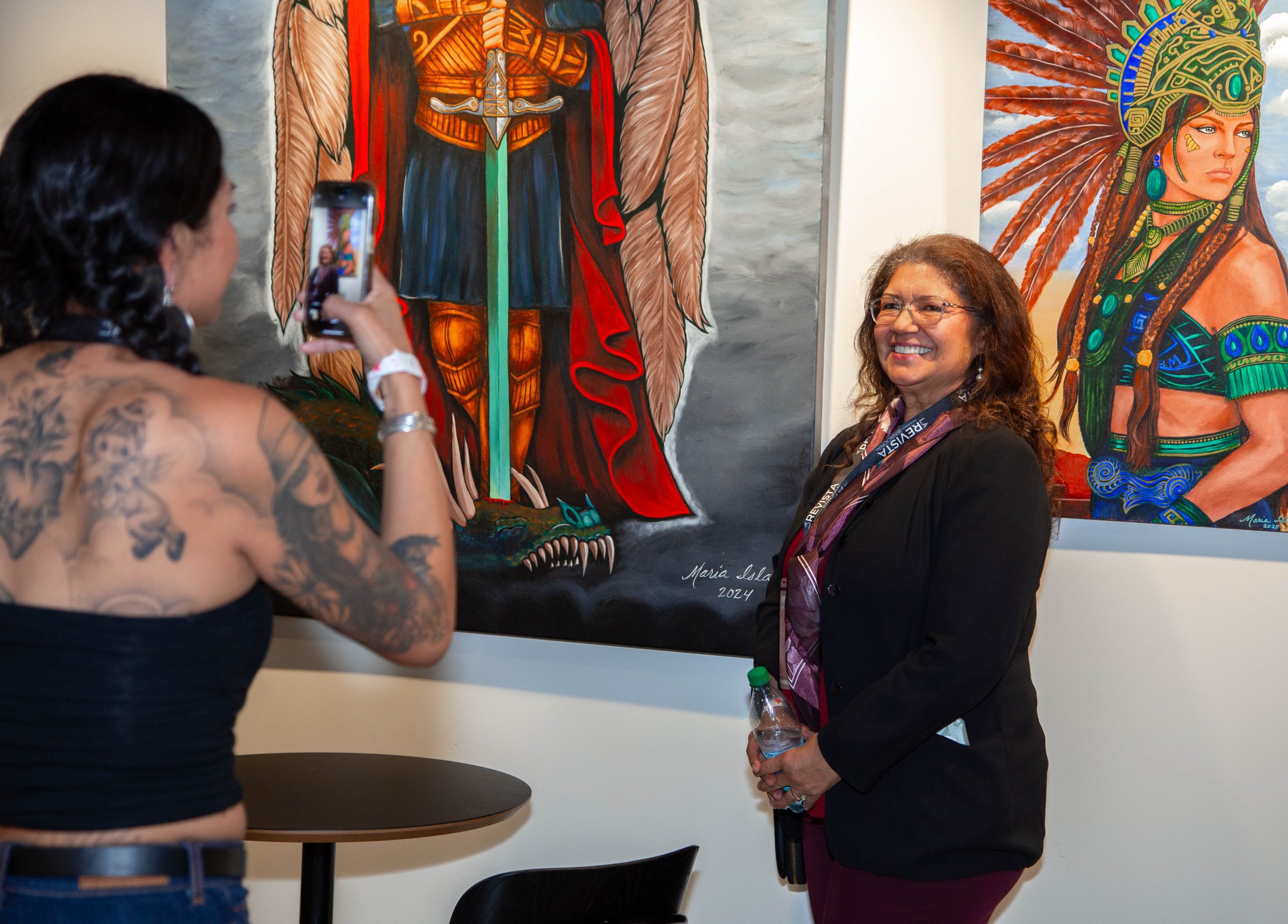 Arte Latino 2025 en el Festival de Cine Latino de San Diego Mujer toma una foto a otra, atrás pinturas